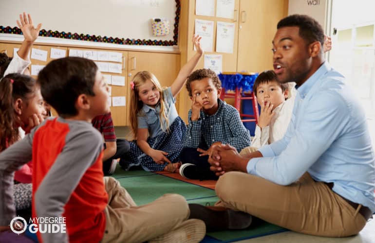 male teacher teaching elementary kids