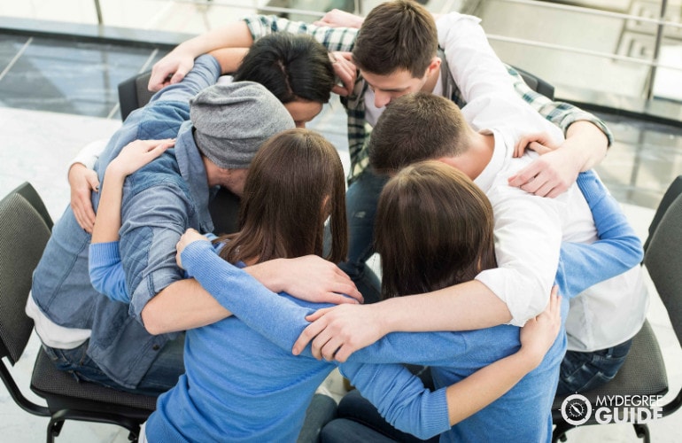 people hugging each other during group counseling
