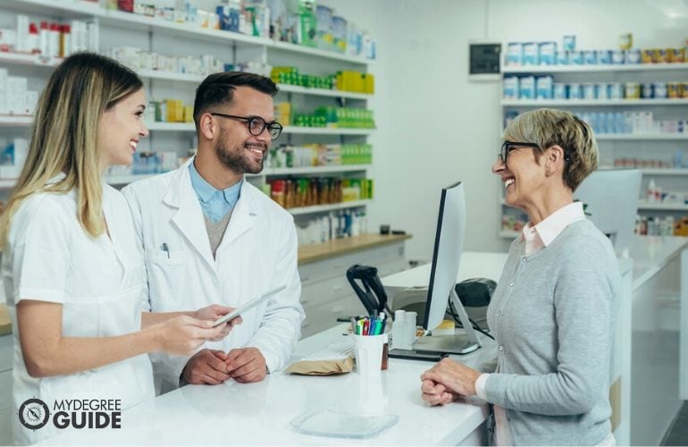 Pharmacists chatting with a customer & pharmacy technician