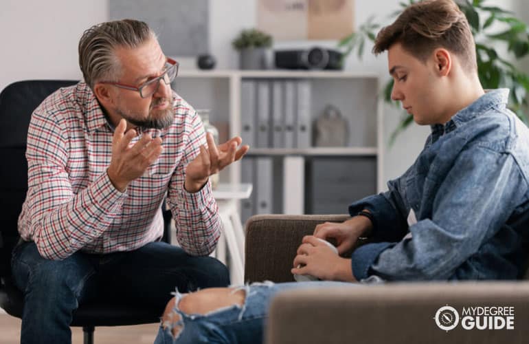 male psychologist talking to a teenage boy