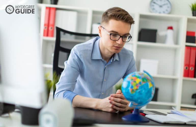 person looking at a globe