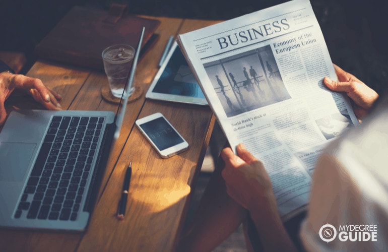 Business professional reading business section of newspaper