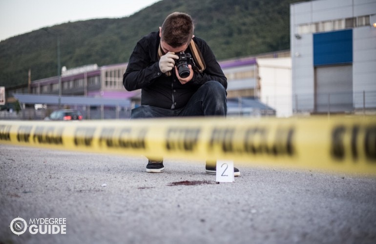 crime scene investigator taking pictures in a crime scene