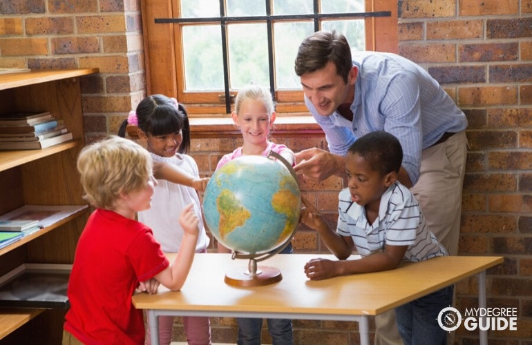 Early Childhood Education teacher teaching his pupils about geography