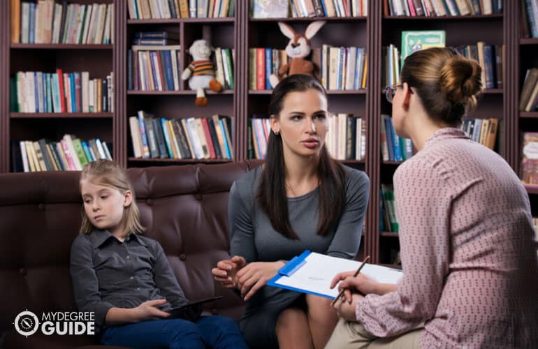female guidance counselor talking to a parent and child
