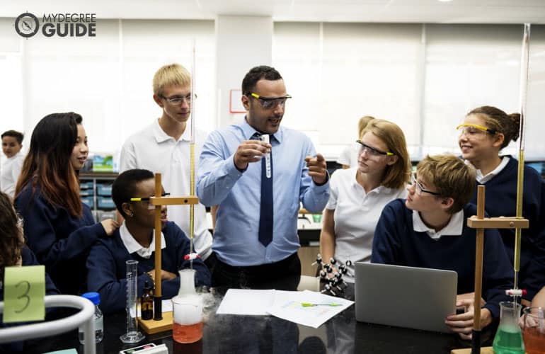 high school teacher doing science experiments with students