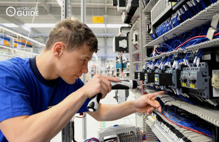 electrical engineer fixes cables in a modern factory