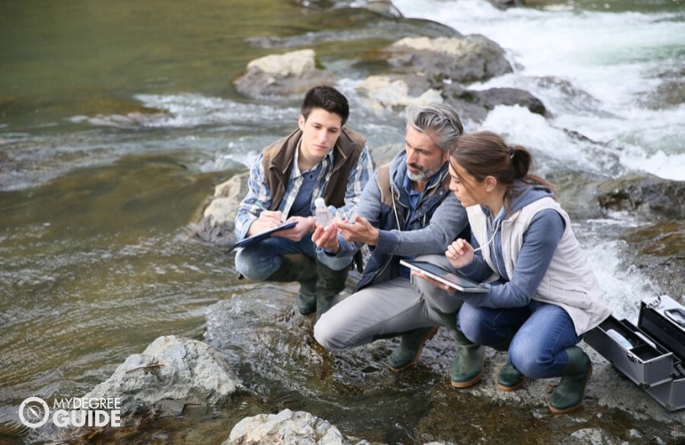 ecologists checking on water samples from a river