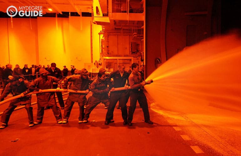 firefighters working together to stop a fire