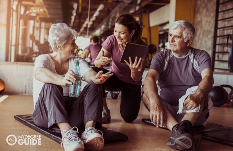 fitness trainer assisting a senior couple