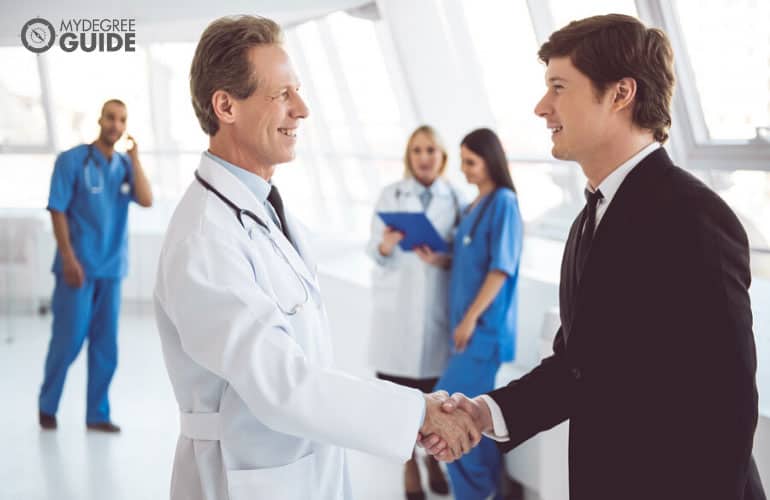 healthcare administrator shaking hands with a colleague