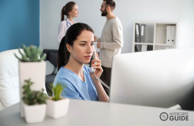 female receptionist talking to phone in a clinic