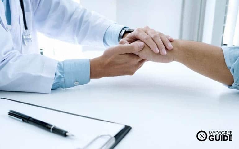 healthcare administration professional shakes patient's hand