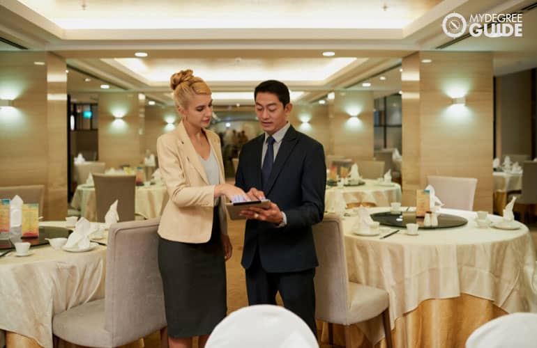 hotel manager talking to an event coordinator in a banquet