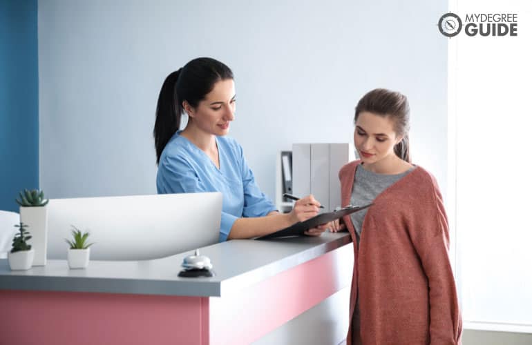 medical receptionist talking to a patient in a clinic