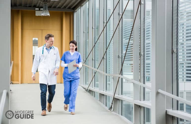 doctor and nurse talking while walking on the hospital hallway