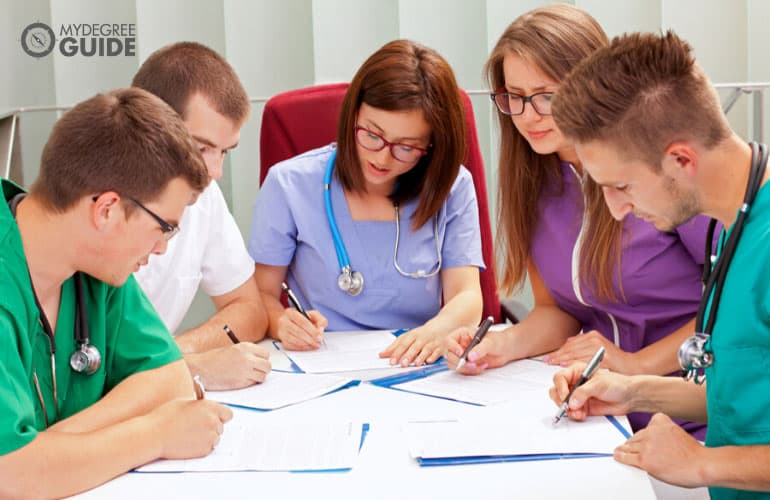 healthcare professionals filling documents during a meeting