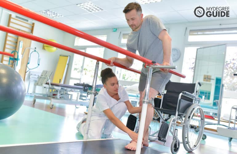 occupational therapist helping patient to walk