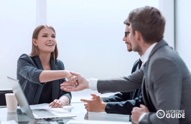 company recruiters shaking hands with potential employee during job interview