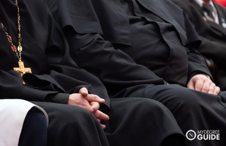 clergy and priests sitting in a church