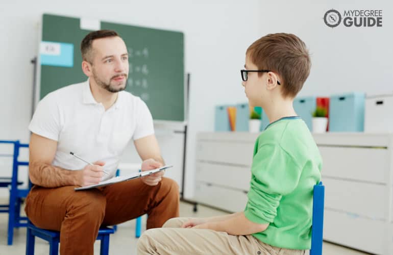 school counselor talking to a young boy
