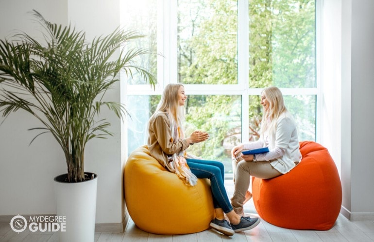 young woman with psychologist comfortably talking in an office