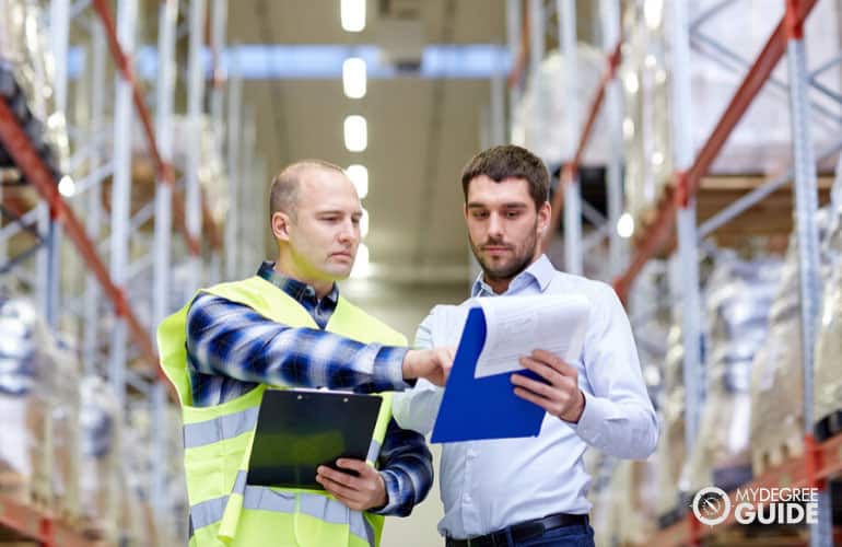 logistics manager talking to an employee in a warehouse