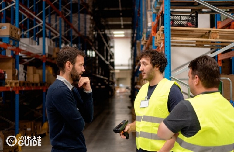 supply chain manager talking to warehouse employees