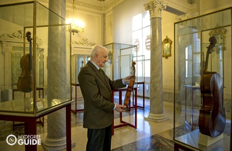 Violin Curator with his collection in a museum