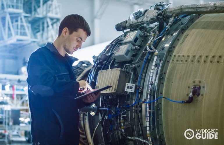 Aerospace Engineer checking the engine of an airplane