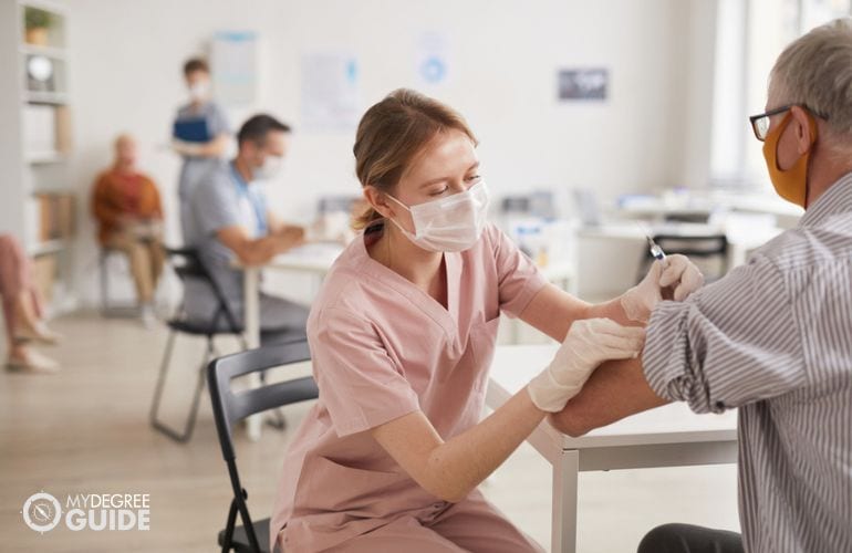 medical assistant administering injection to a patient